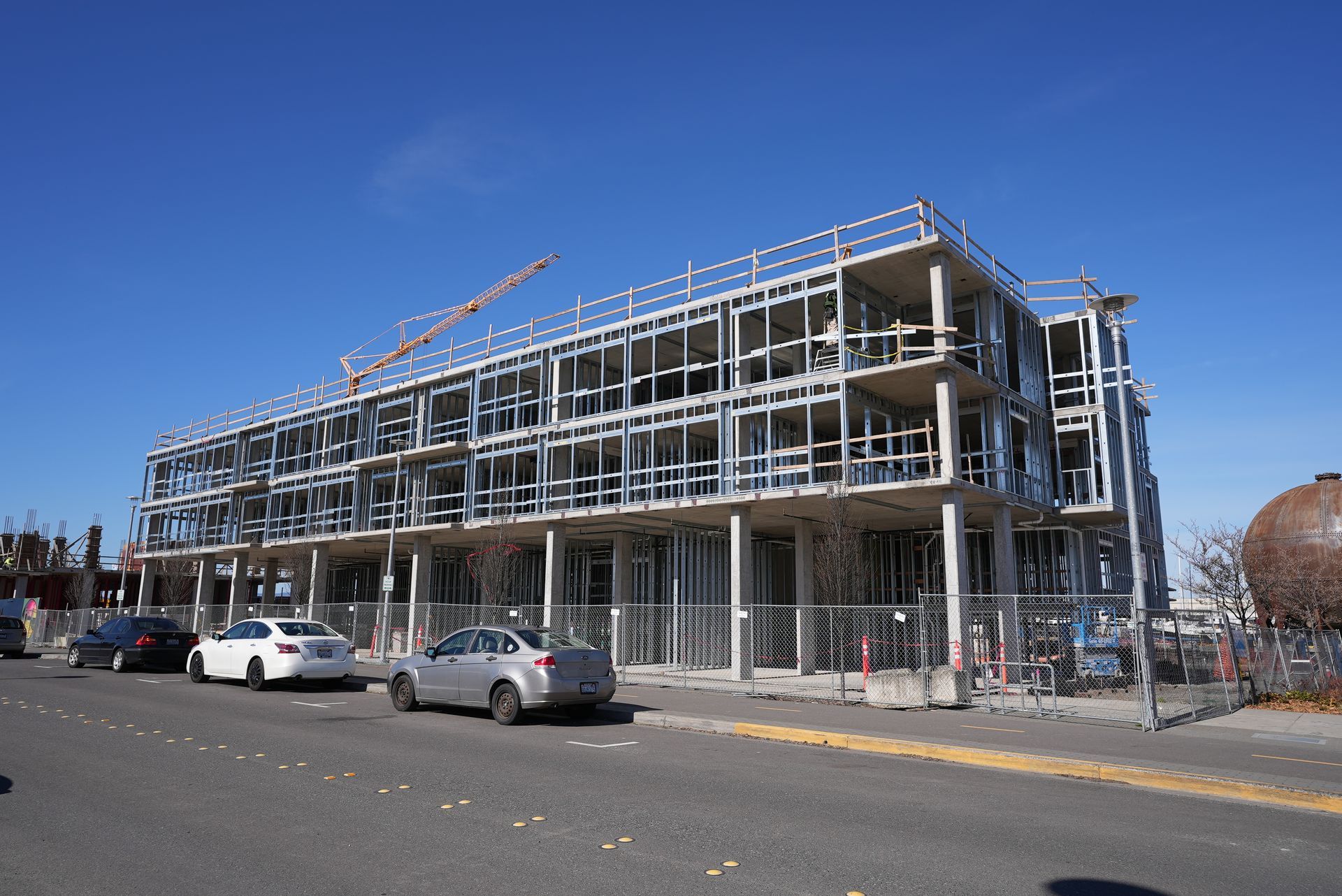 A building under construction with cars parked in front of it