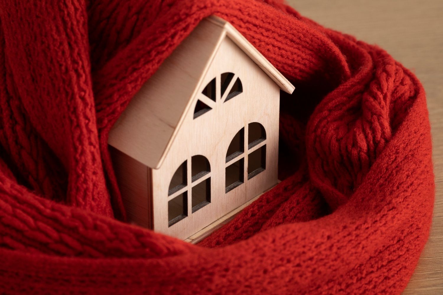 A small house is wrapped in a red scarf.