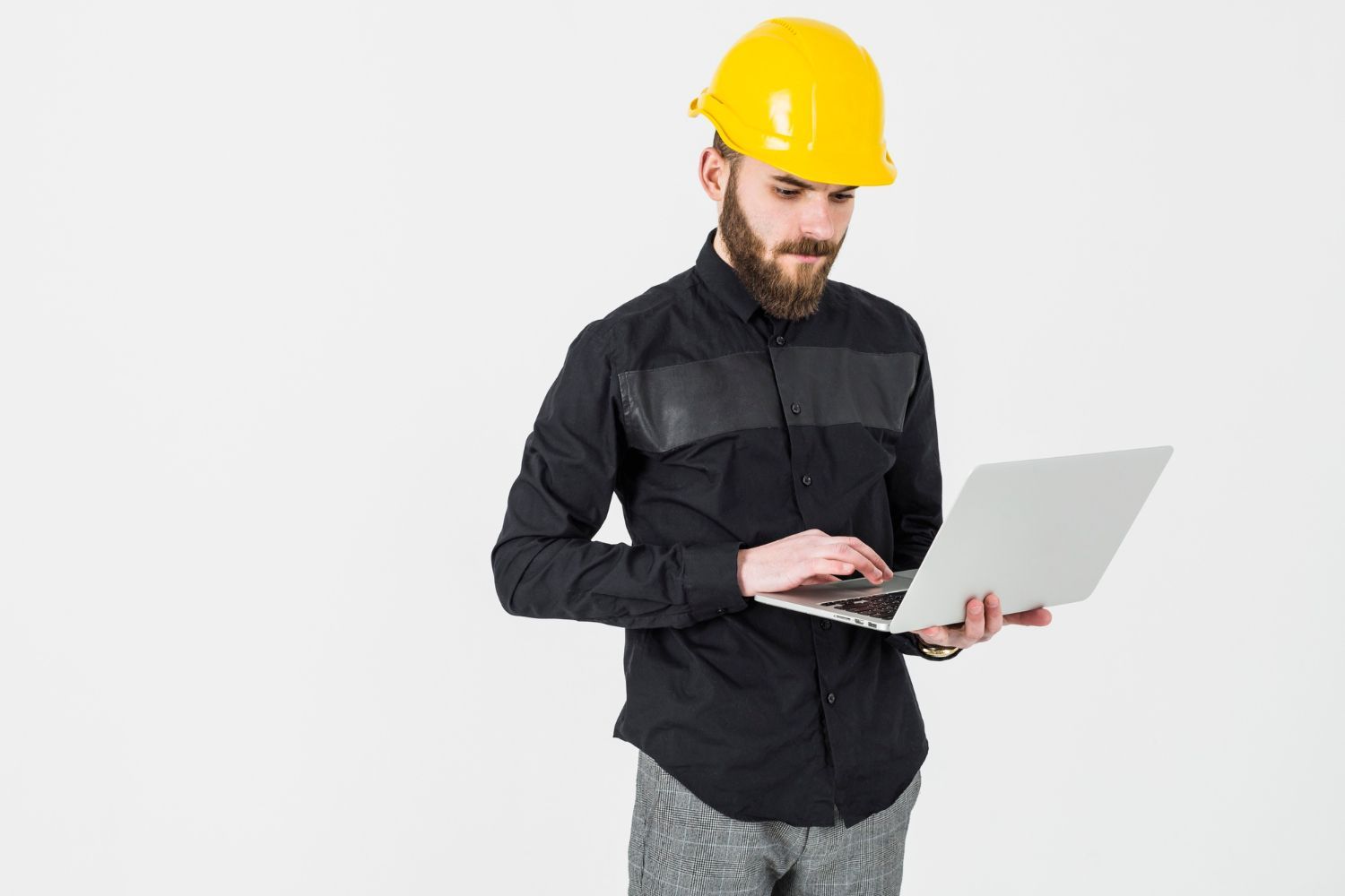 A man wearing a hard hat is using a laptop computer.