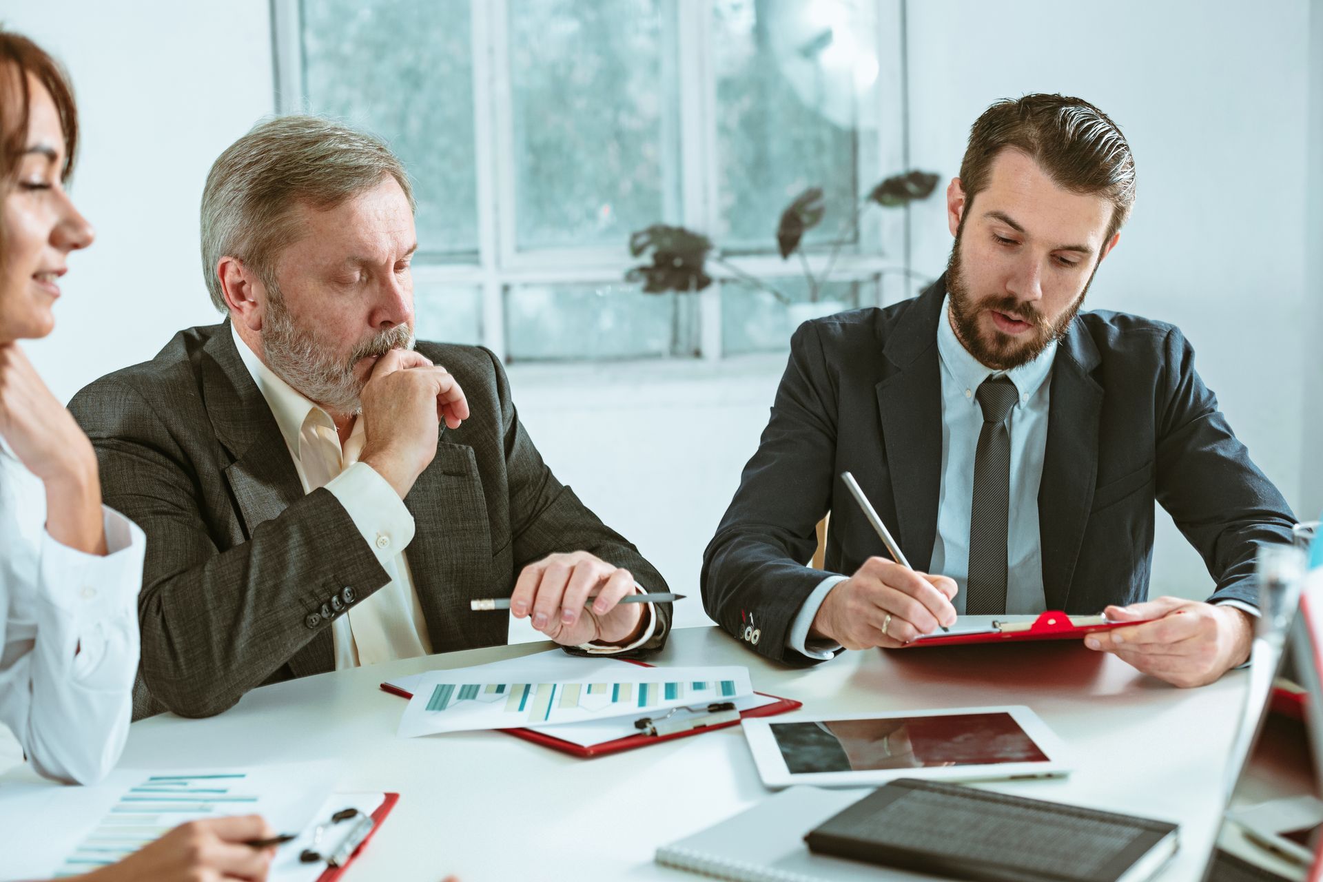A group of business people are sitting at a table having a meeting.