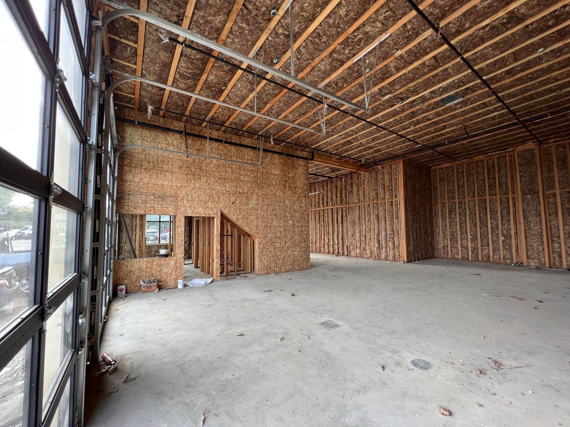 A large empty room with wooden walls and a garage door.