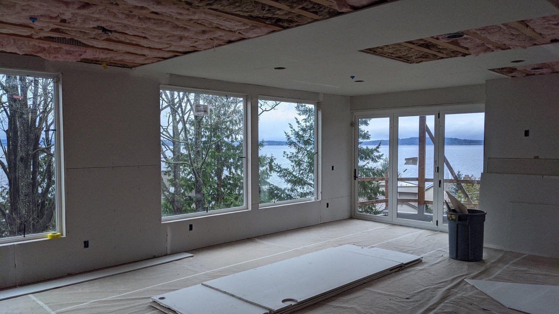 A large room with a lot of windows and a view of the ocean.