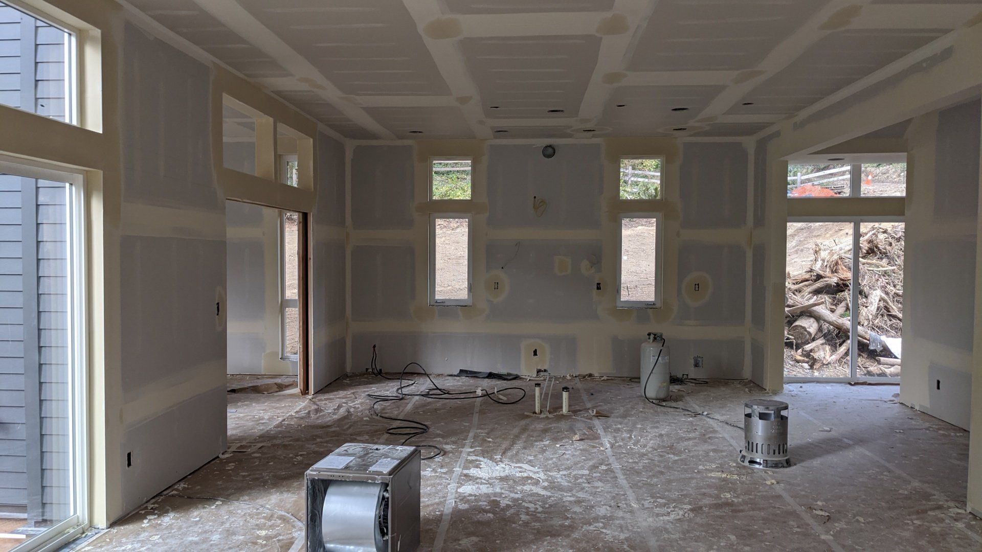 An empty room with a lot of windows and drywall