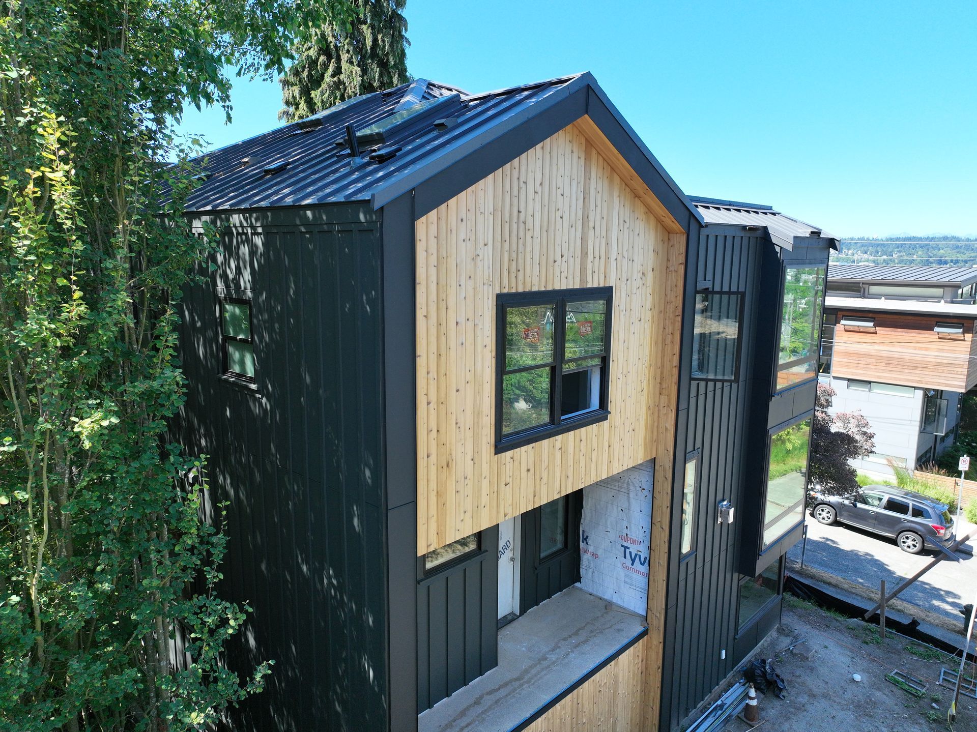 An aerial view of a wooden house with a black roof.