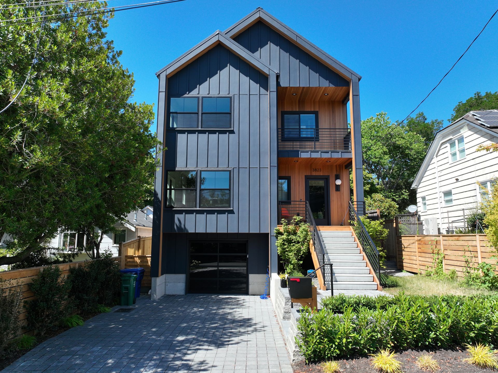 A black and wooden house with stairs leading up to it