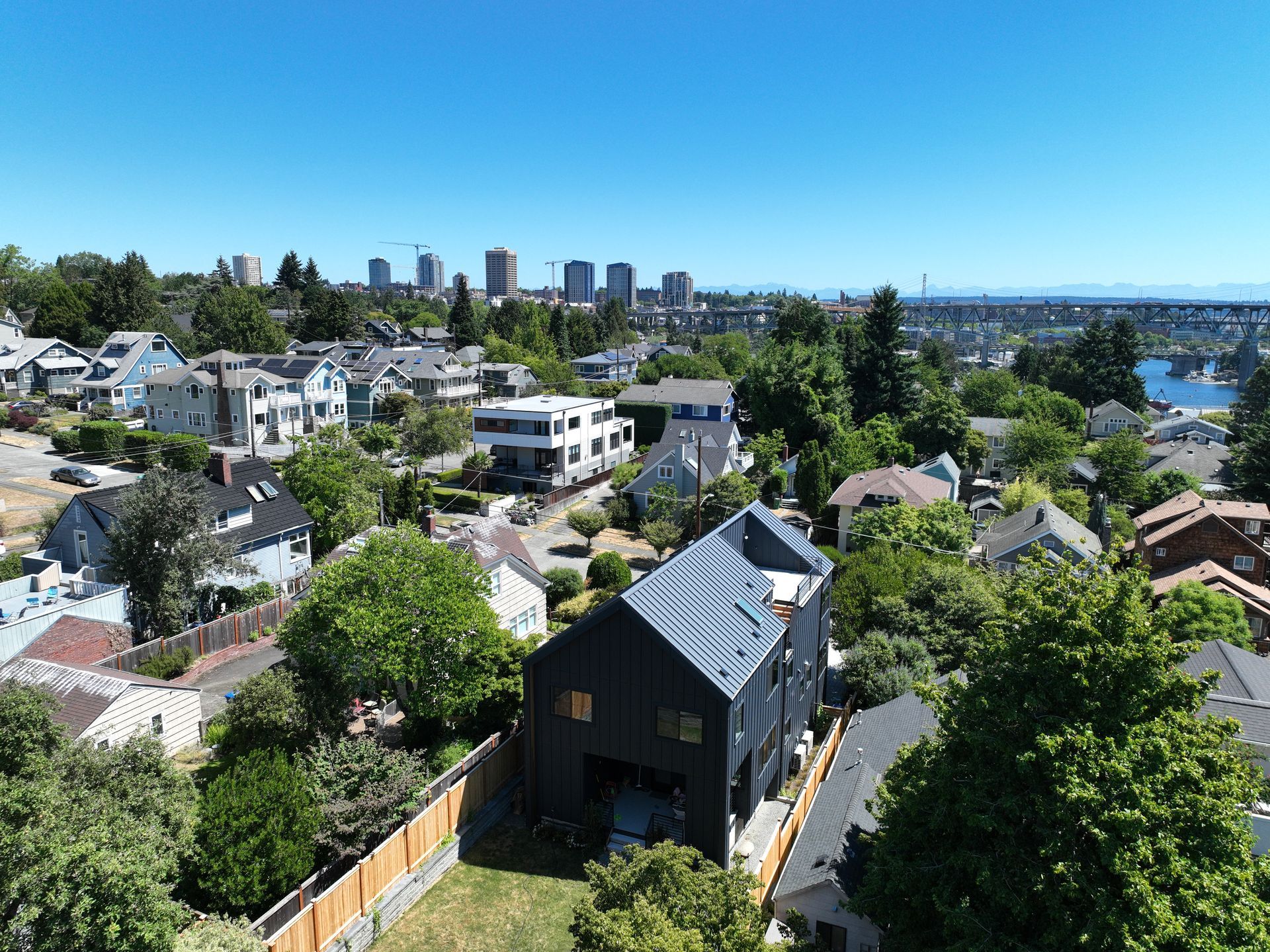 An aerial view of a house in a residential area with a city in the background.
