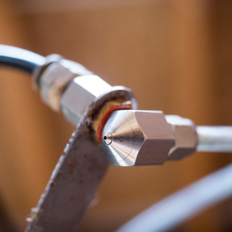 A close up of a metal pipe with a nozzle attached to it.