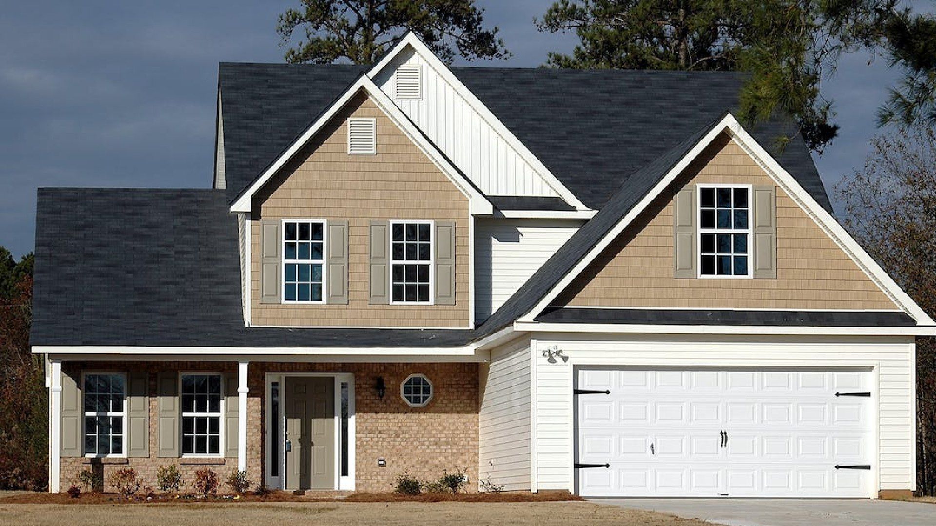 A large house with a black roof and white trim