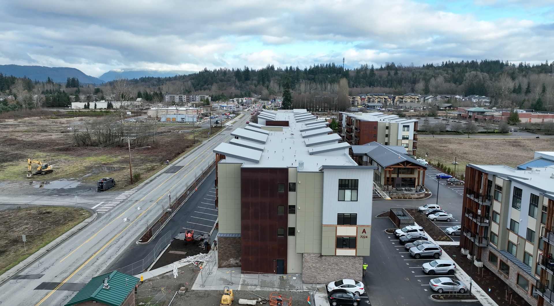 An aerial view of a building with a lot of cars parked in front of it.
