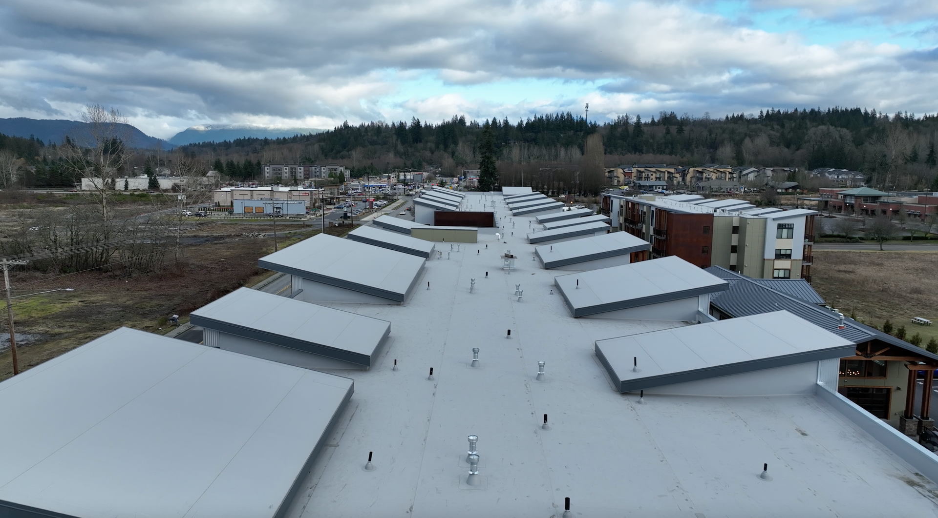 An aerial view of the roof of a building with mountains in the background.