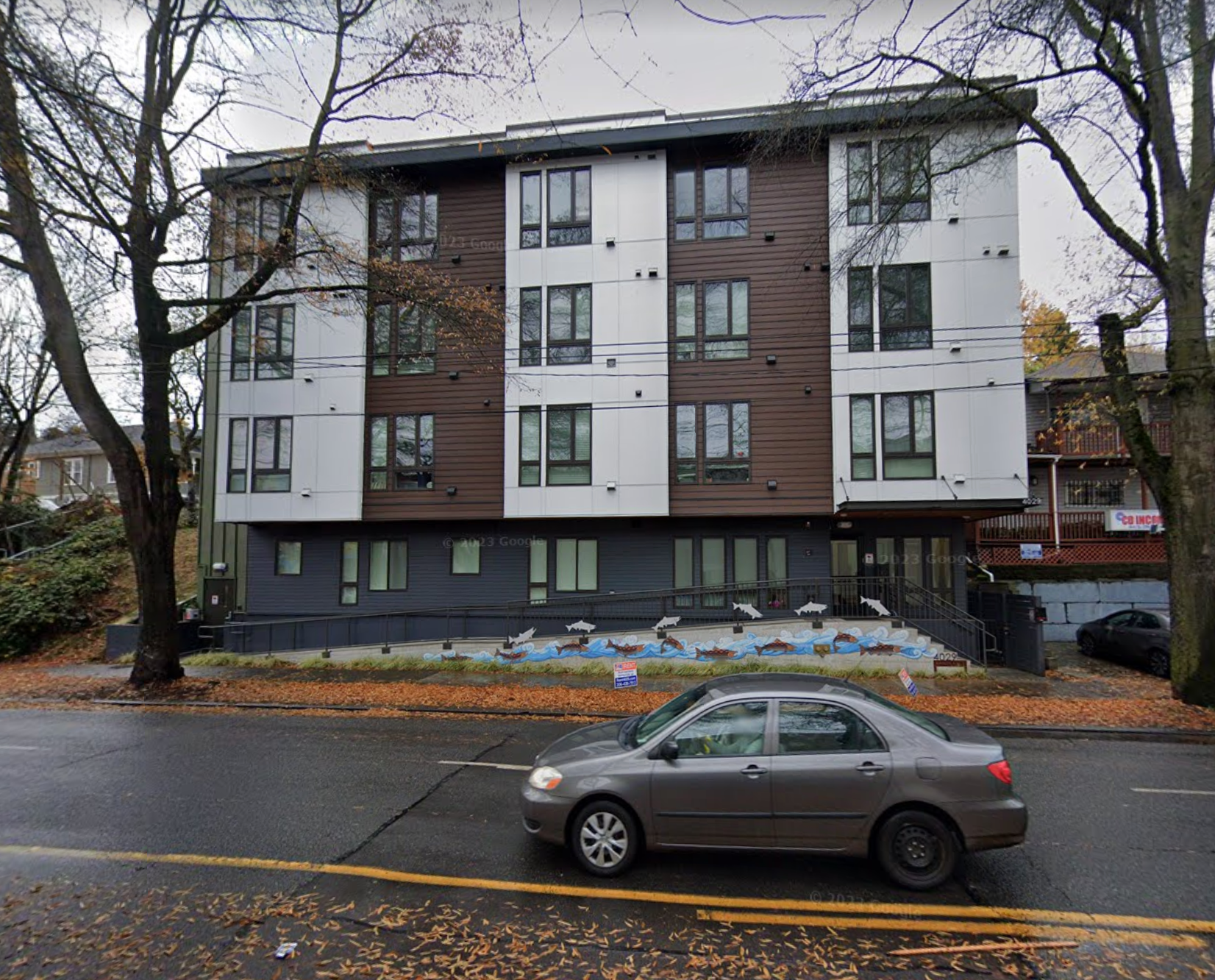 A car is parked in front of a large apartment building