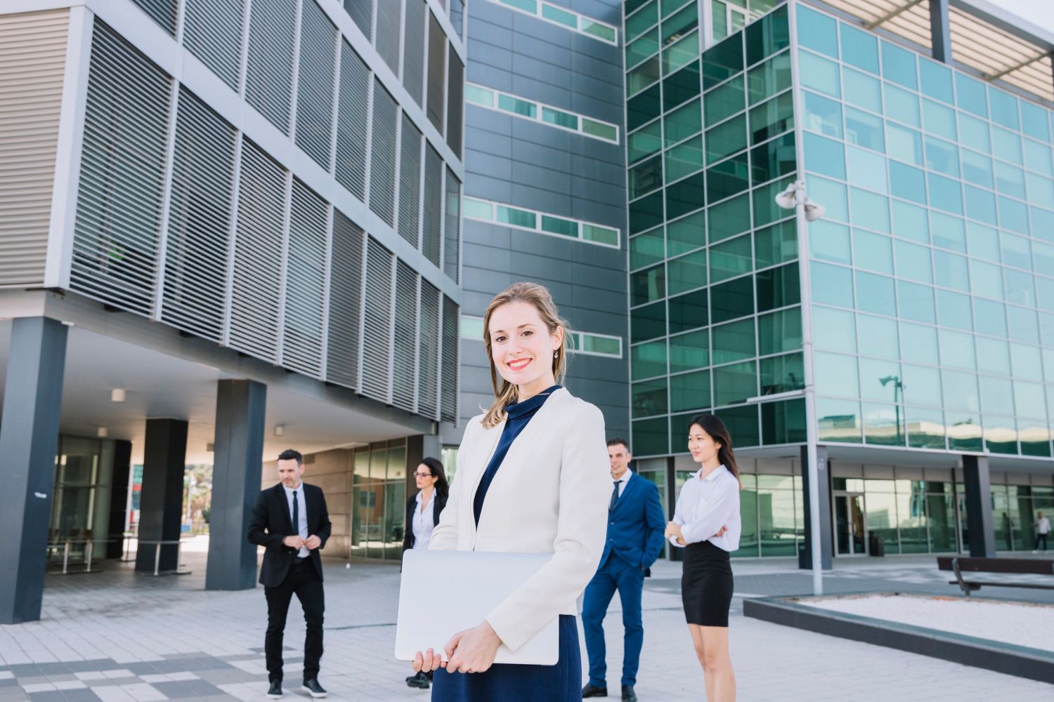 A group of business people are standing in front of a large building.