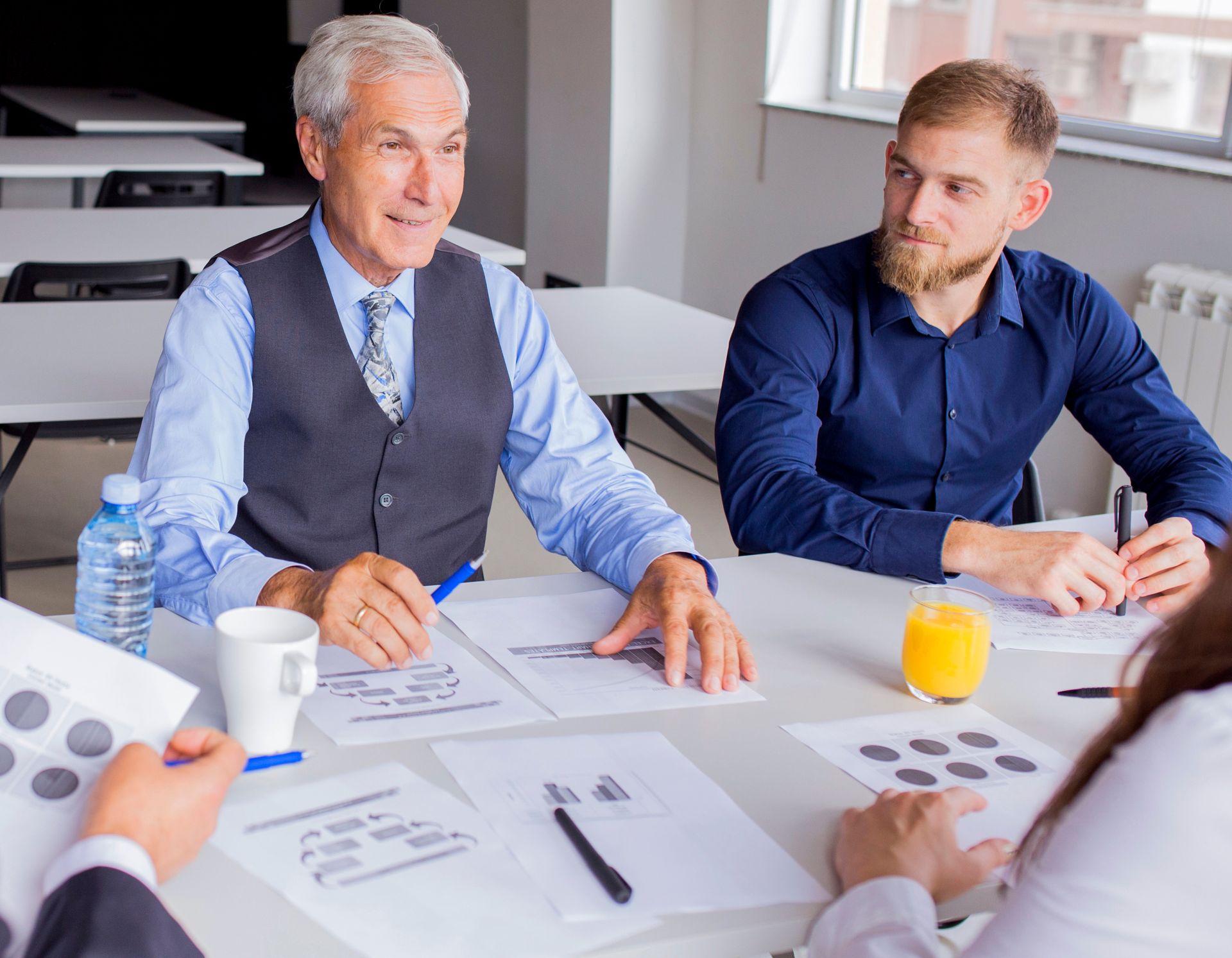 A group of people are sitting around a table having a meeting.