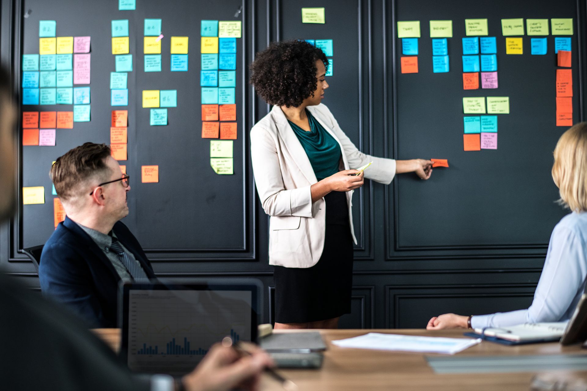 A woman is giving a presentation to a group of people in a conference room.