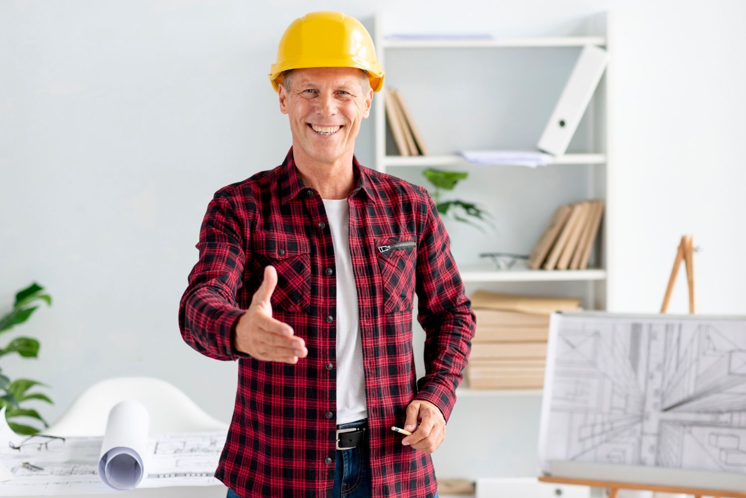 The man is wearing a hard hat and giving a handshake.