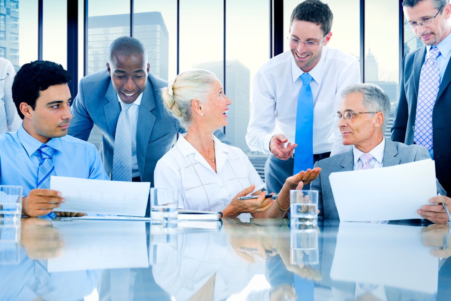 A group of business people are sitting around a table having a meeting.