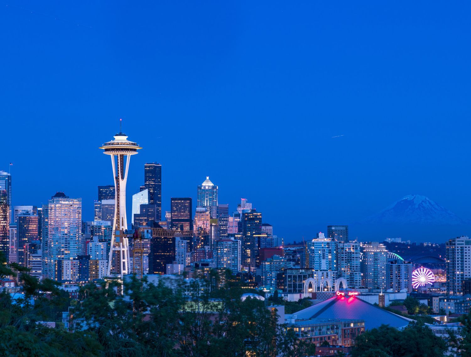 The skyline of seattle at night with the space needle in the foreground.
