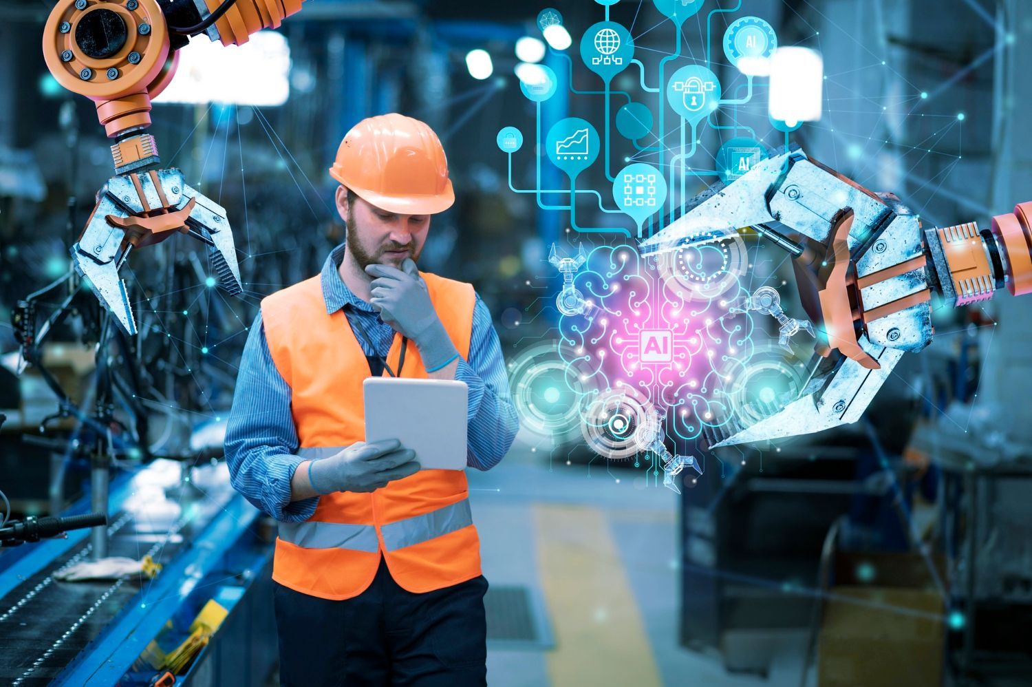A man in a hard hat is holding a tablet in a factory.