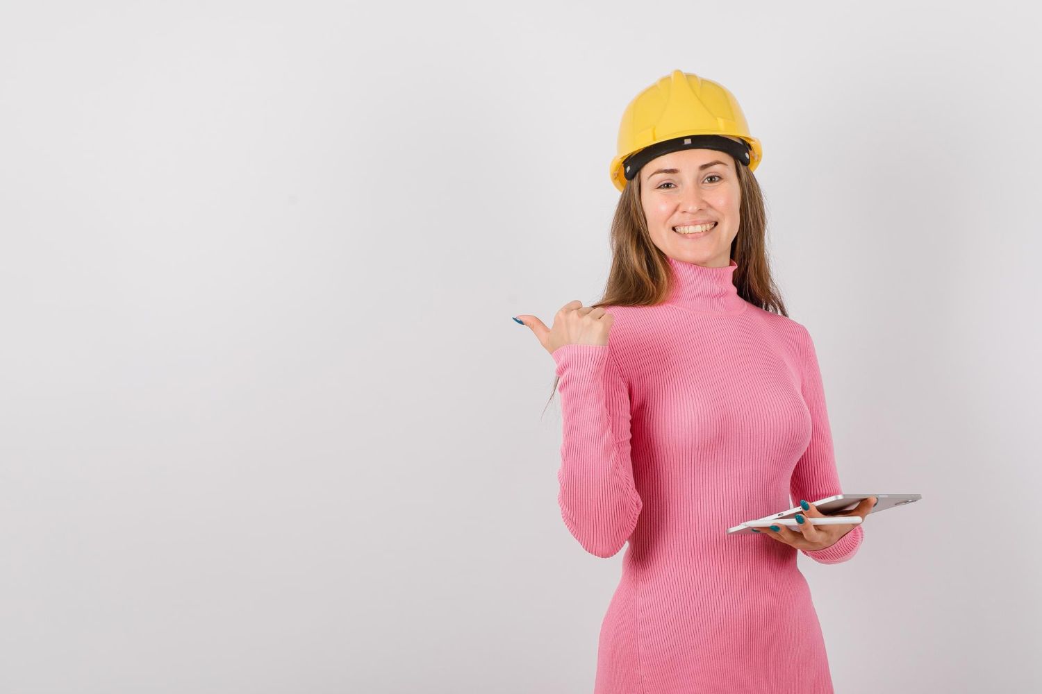 The woman is wearing a hard hat and holding a clipboard.