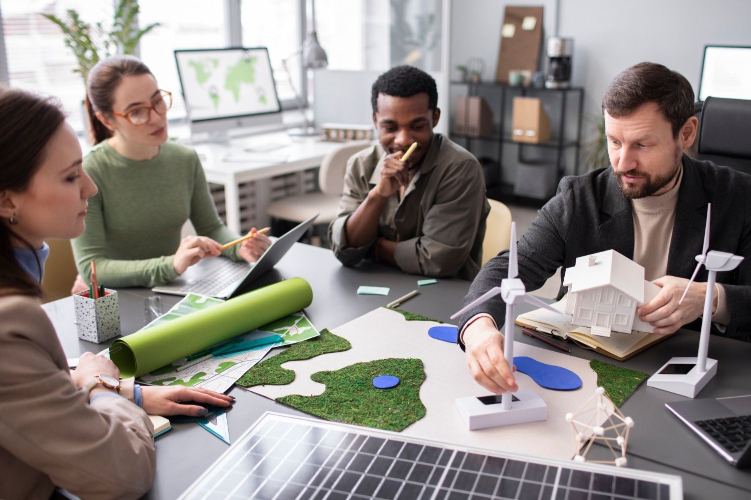 A group of people are sitting around a table working on a project.