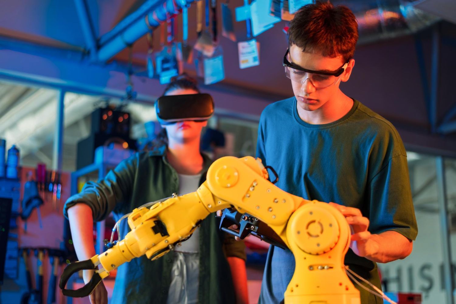 A man wearing a virtual reality headset is working on a robotic arm.