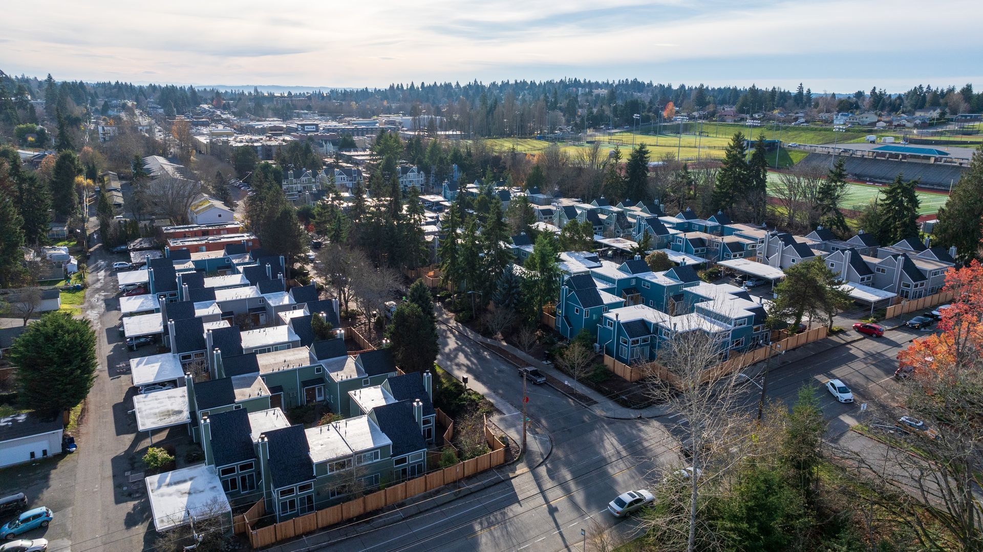an aerial view of a large apartment building under construction An aerial view of a residential area with lots of houses and trees.