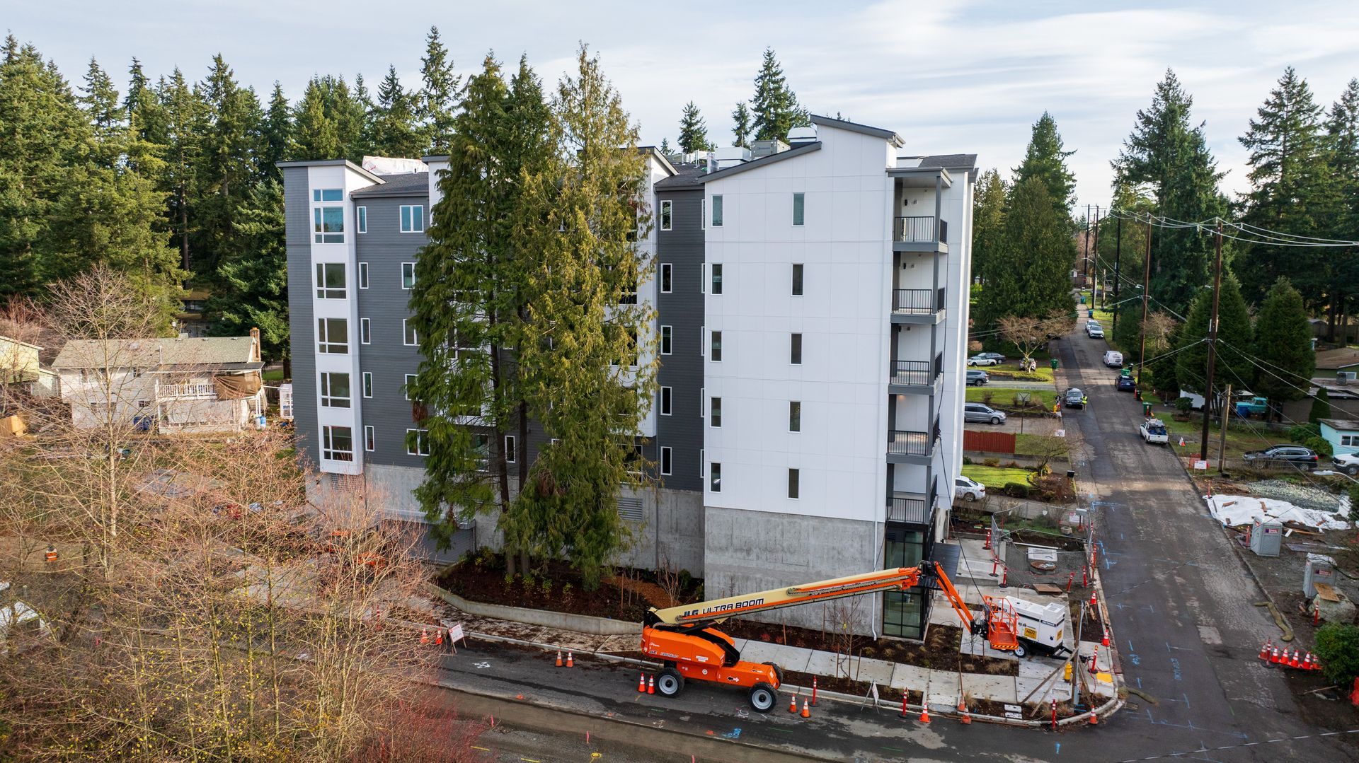 An aerial view of a building under construction in the middle of a forest.