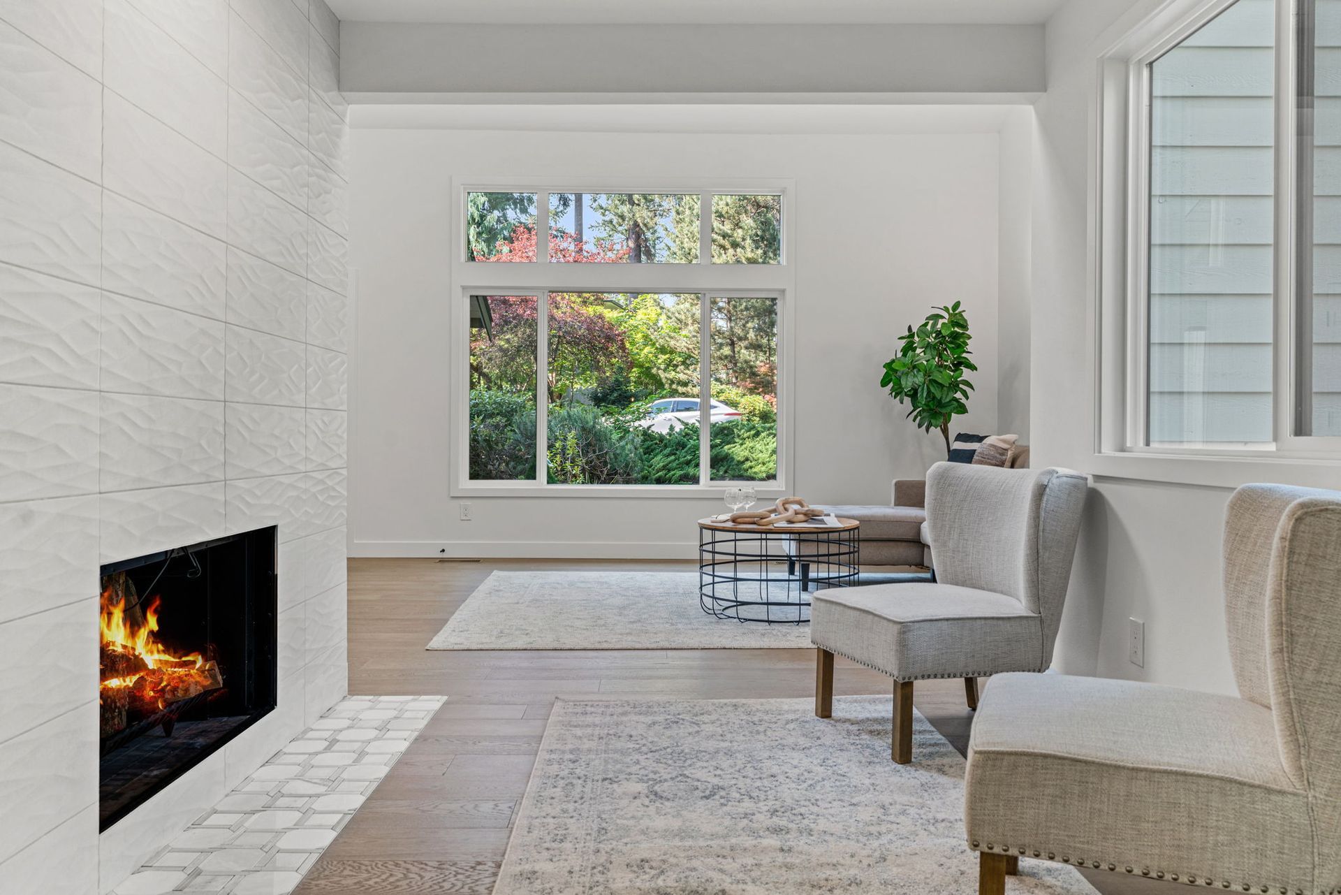 A living room with a fireplace , chairs and a couch.