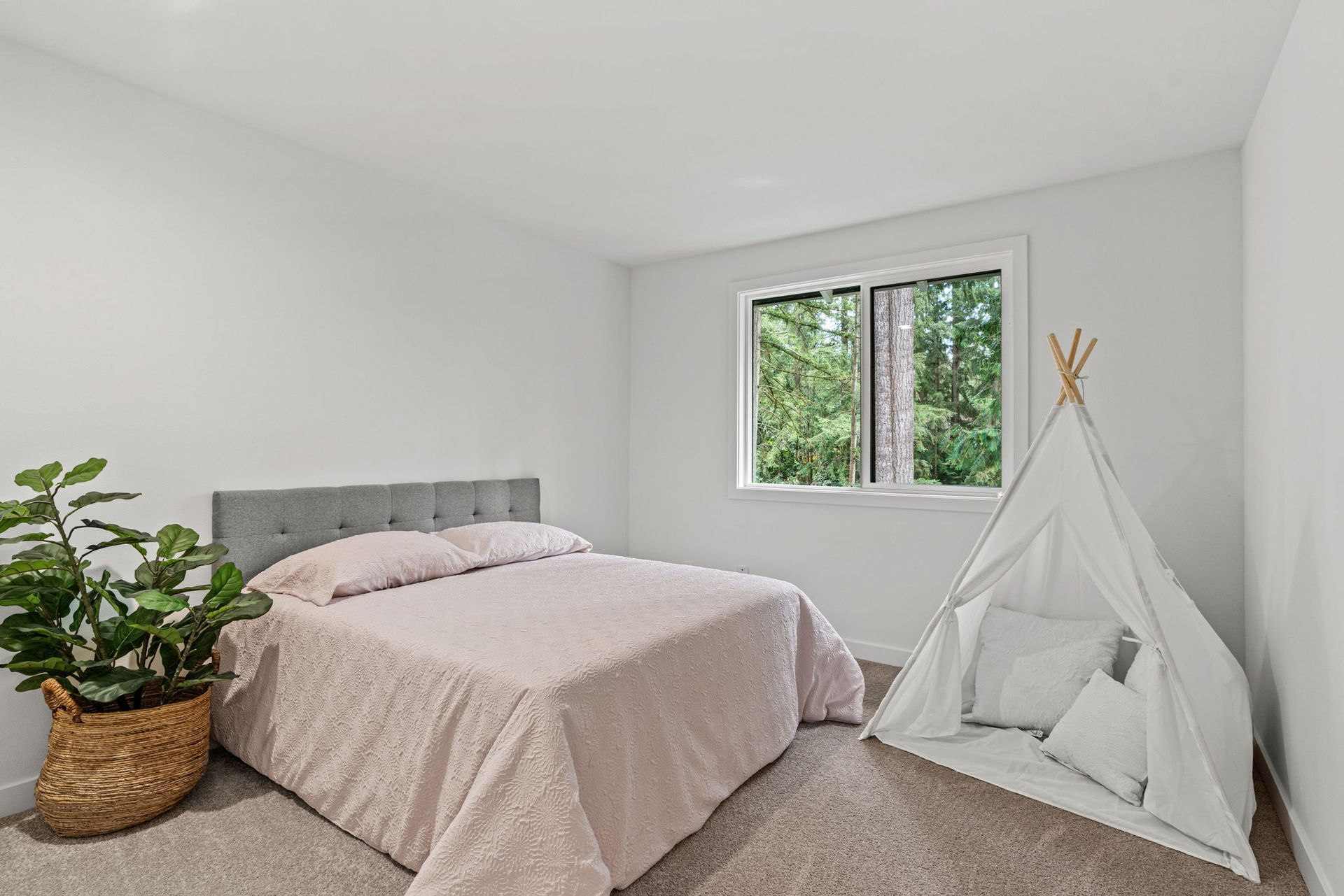 There is a teepee in the middle of the room next to the bed.