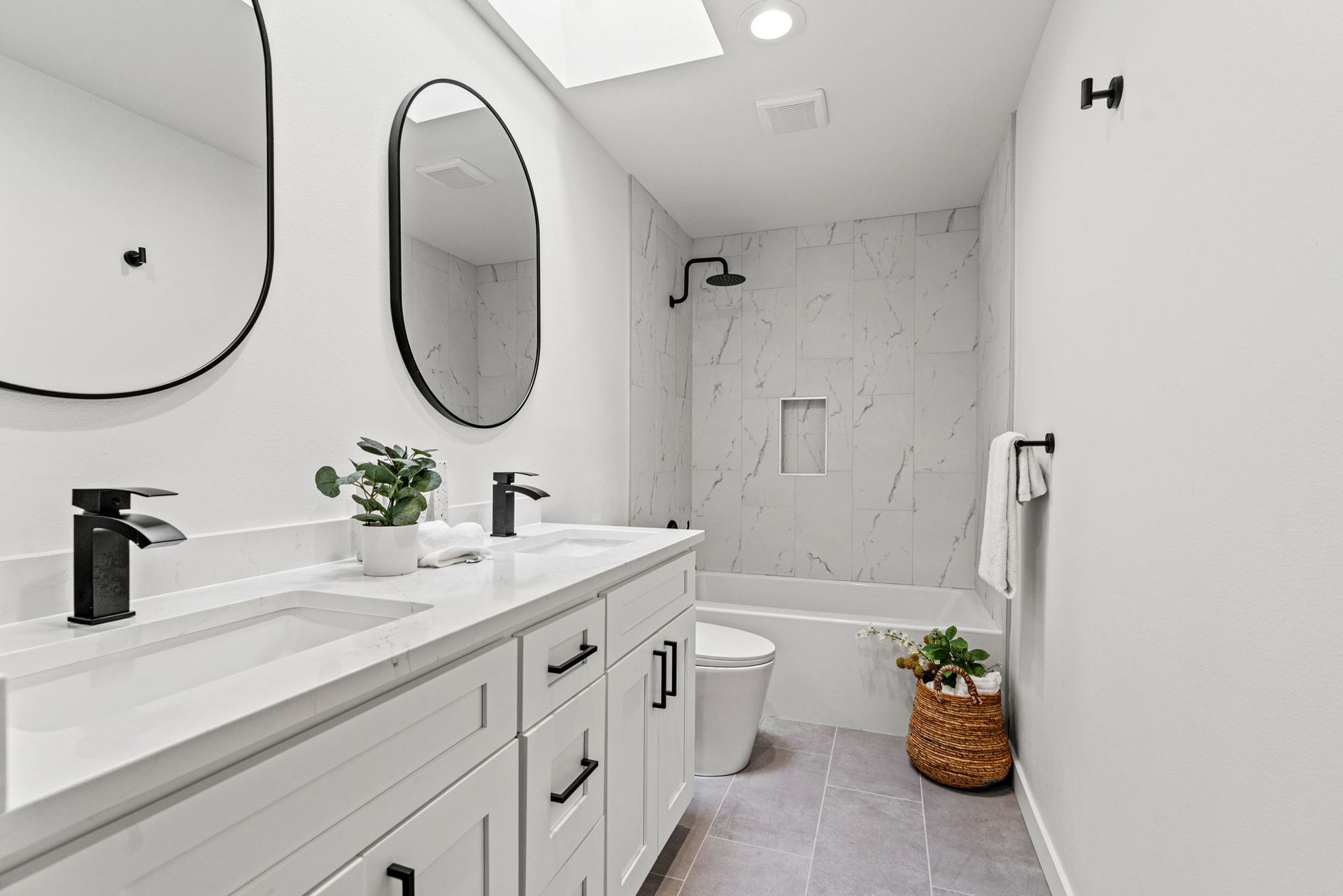 A bathroom with two sinks , a toilet , and a shower.