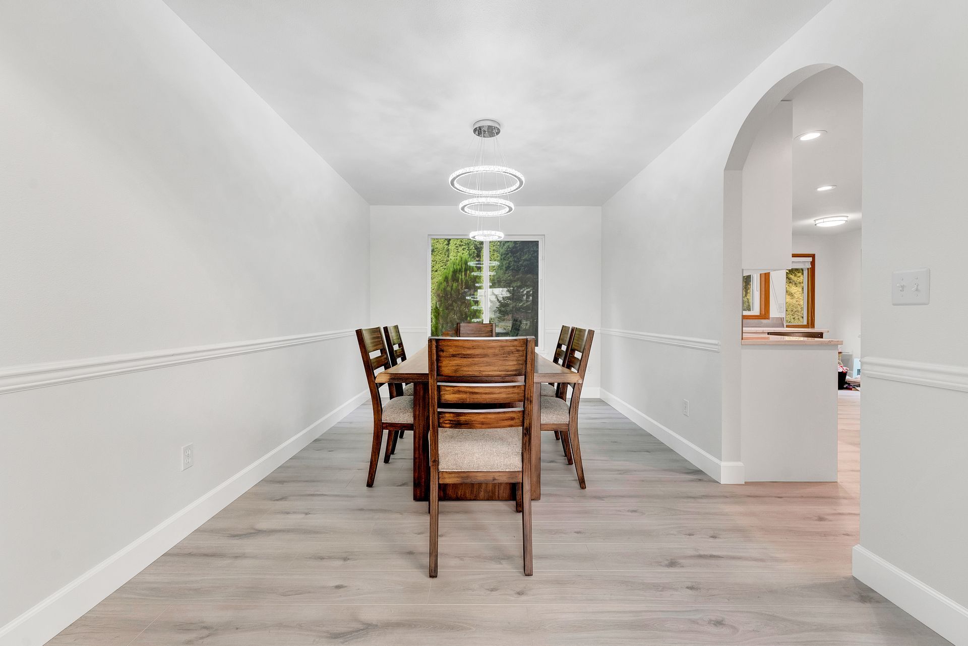 A dining room with a wooden table and chairs in a house.