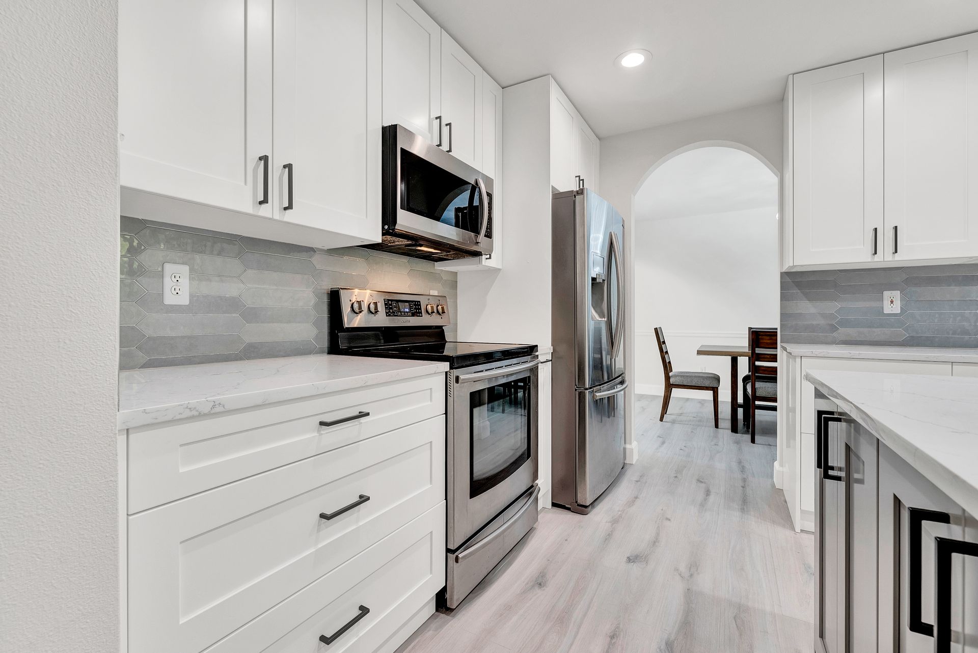 A kitchen with white cabinets and stainless steel appliances.