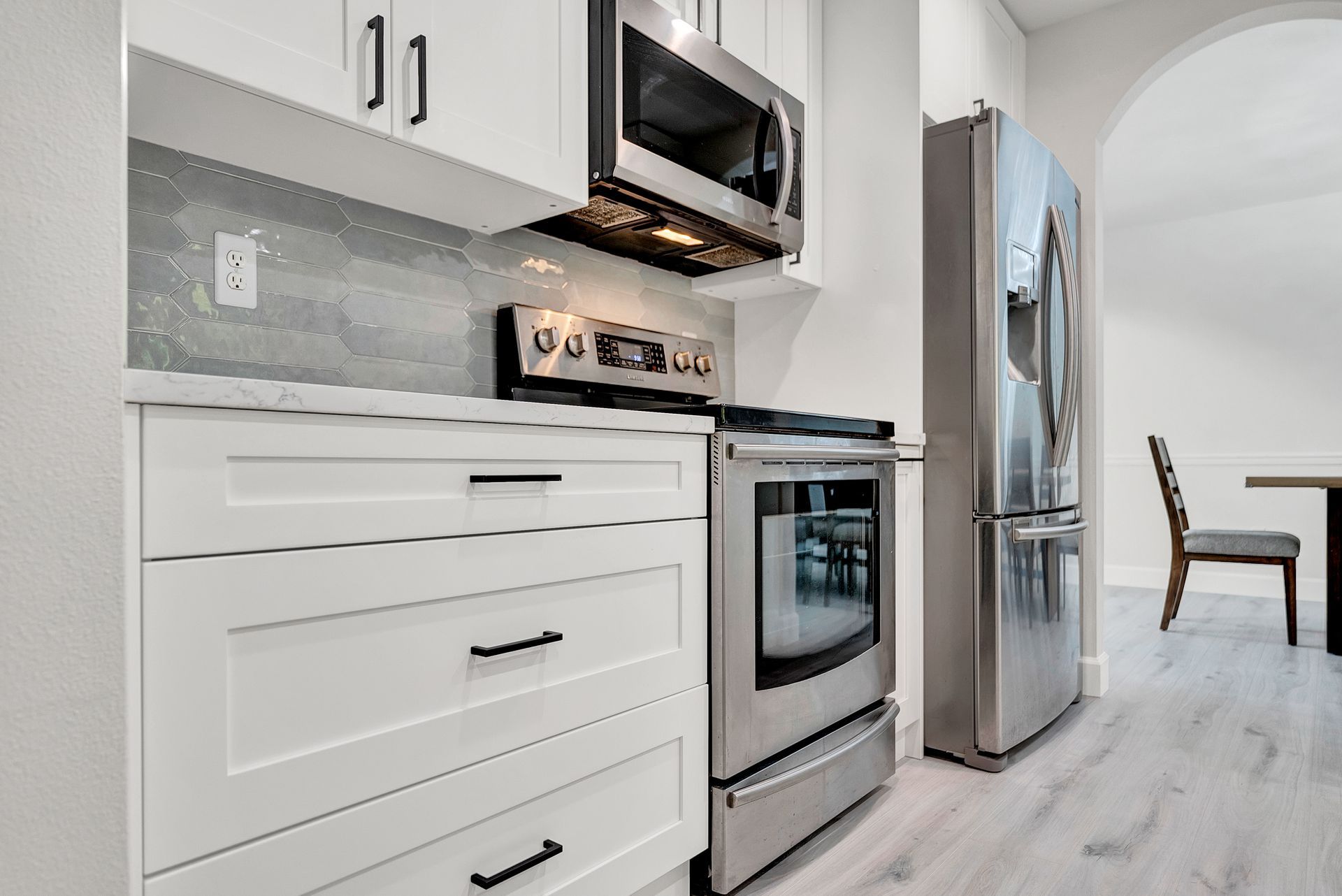 A kitchen with stainless steel appliances and white cabinets