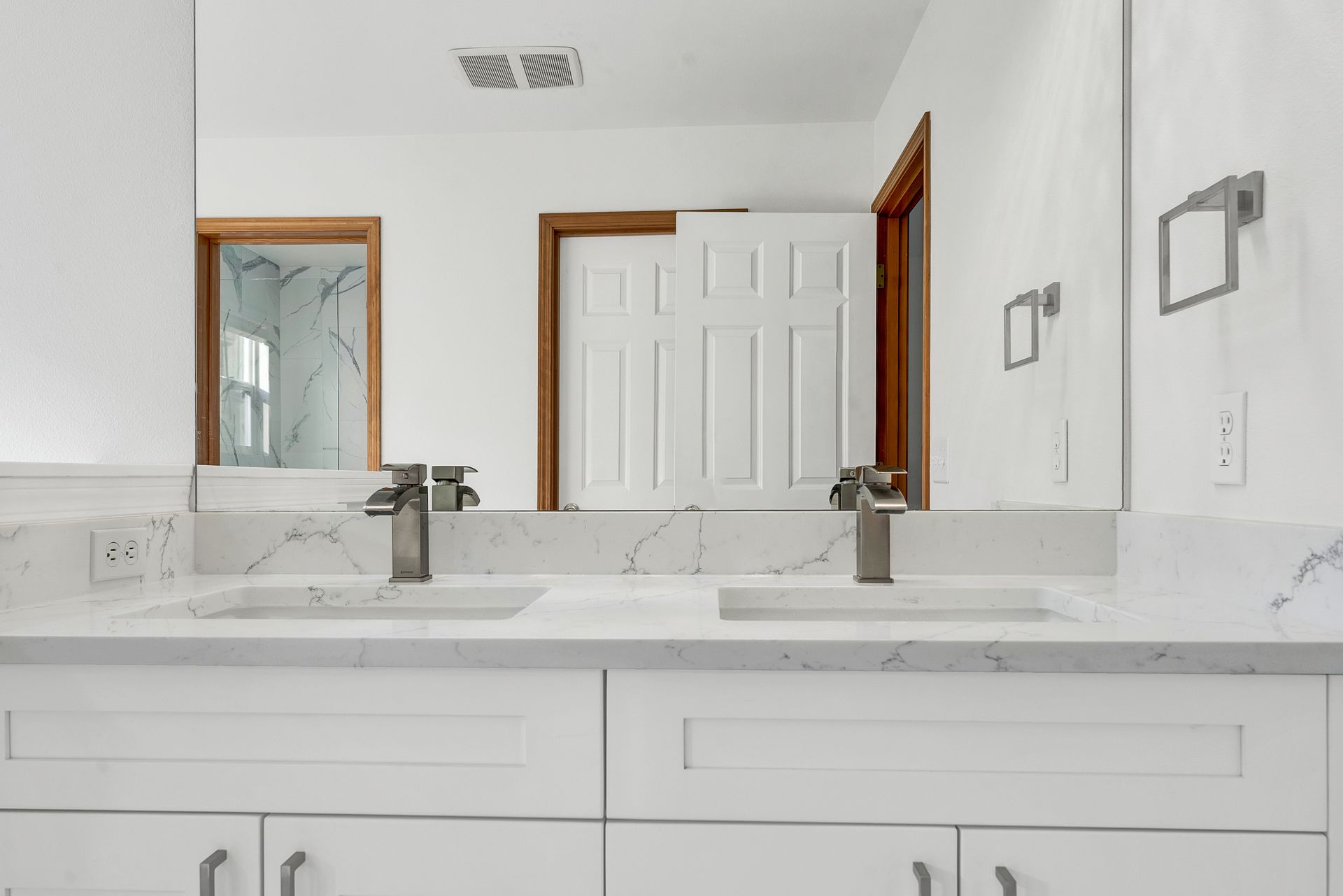 A bathroom with two sinks and a large mirror.