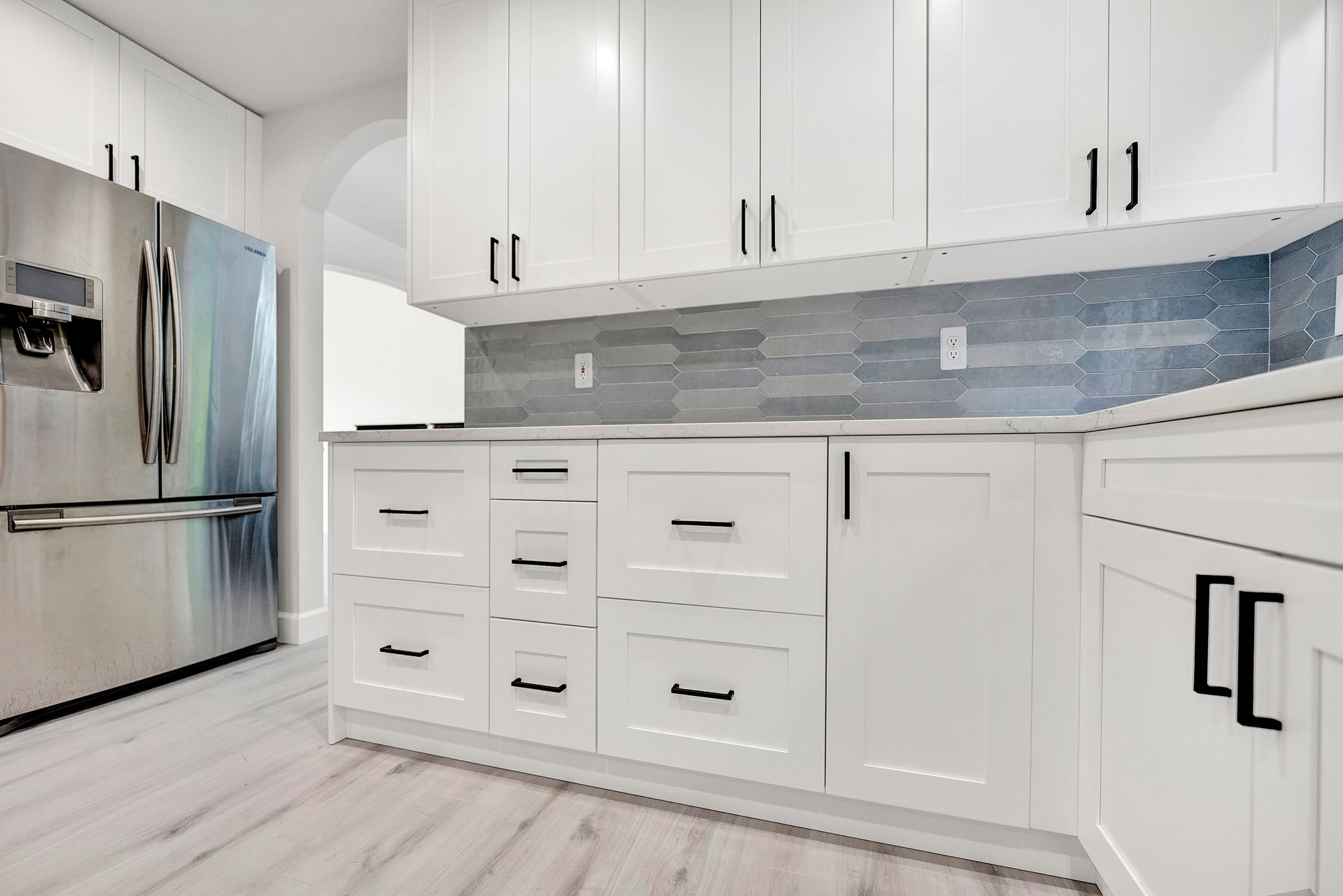 A kitchen with white cabinets and stainless steel appliances.