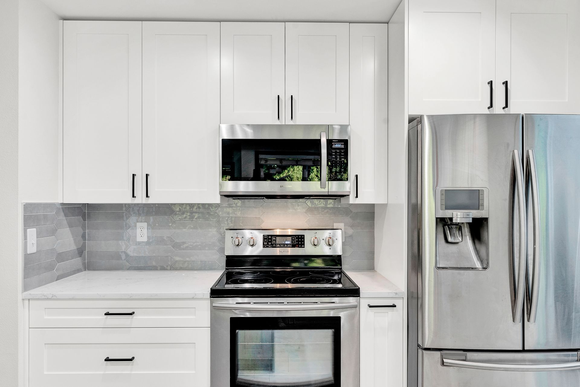 A kitchen with stainless steel appliances and white cabinets.