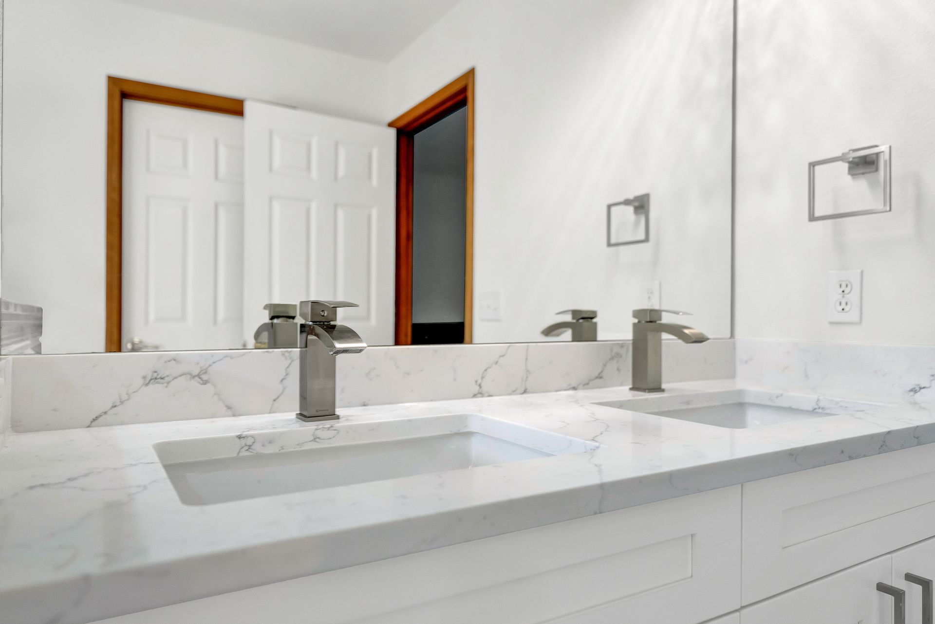 A bathroom with two sinks and a large mirror.
