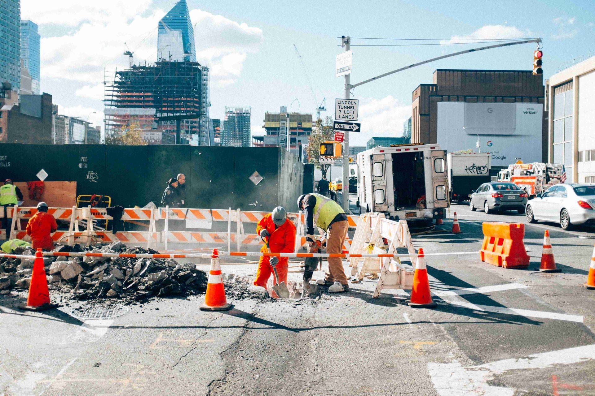 A group of construction workers are working on a street.