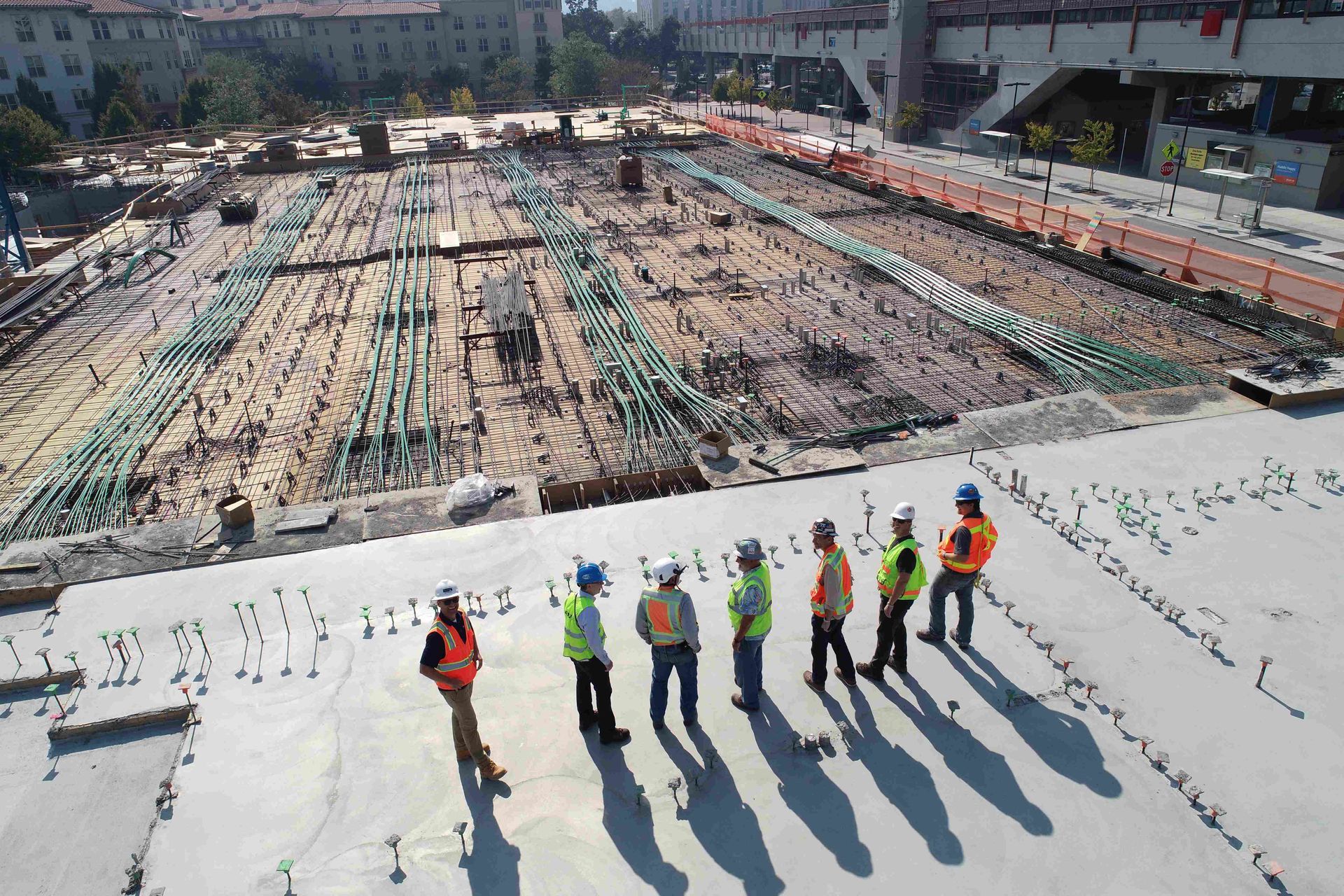 A group of construction workers are standing on top of a construction site.