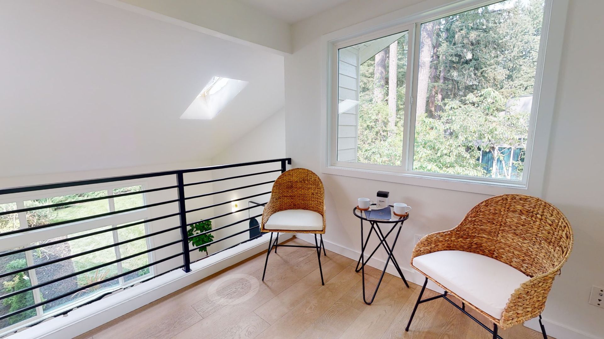 A balcony with two chairs and a table next to a window.