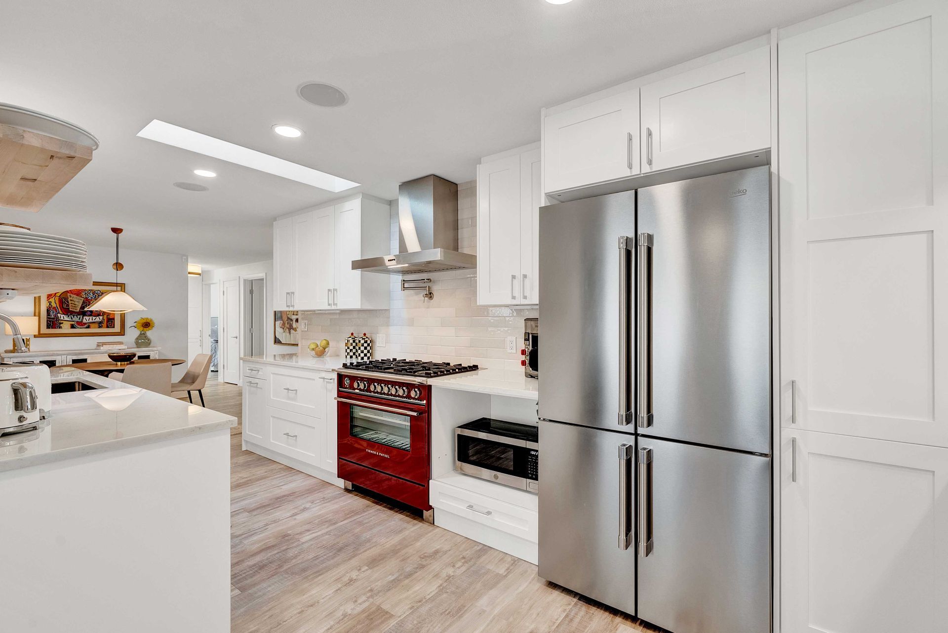 A kitchen with stainless steel appliances and white cabinets.
