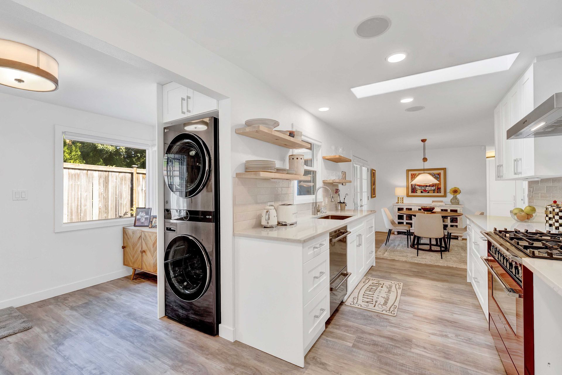 A kitchen with a washer and dryer stacked on top of each other.