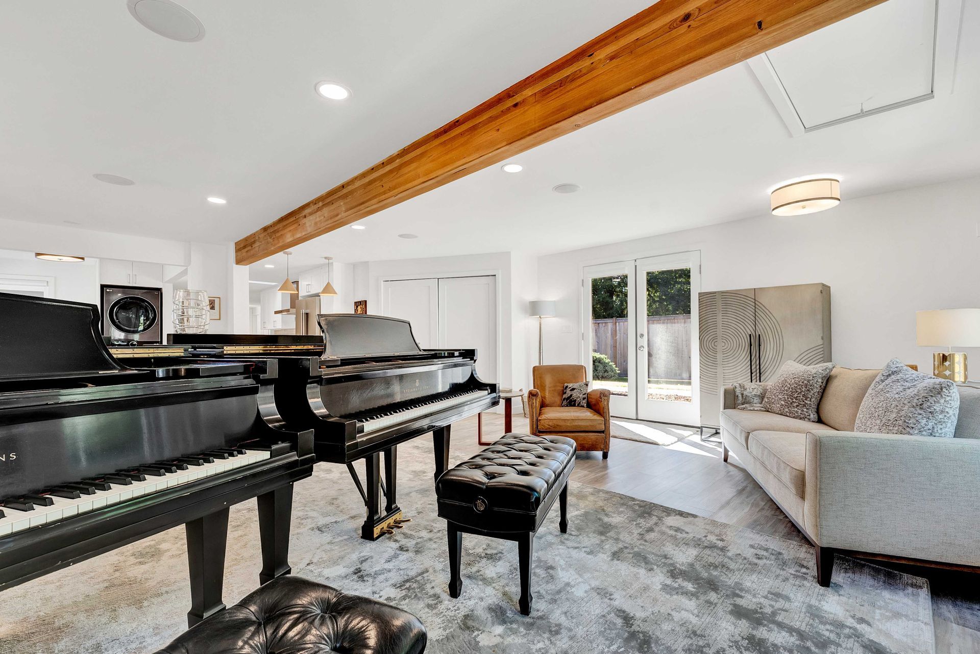 A living room with two pianos and a couch.
