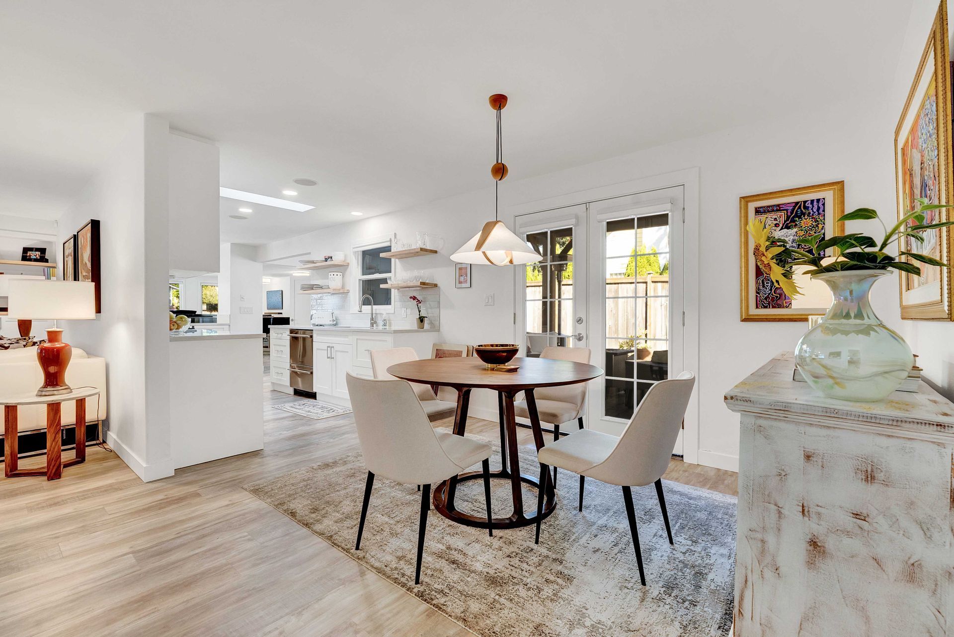 A dining room with a table and chairs and a rug.