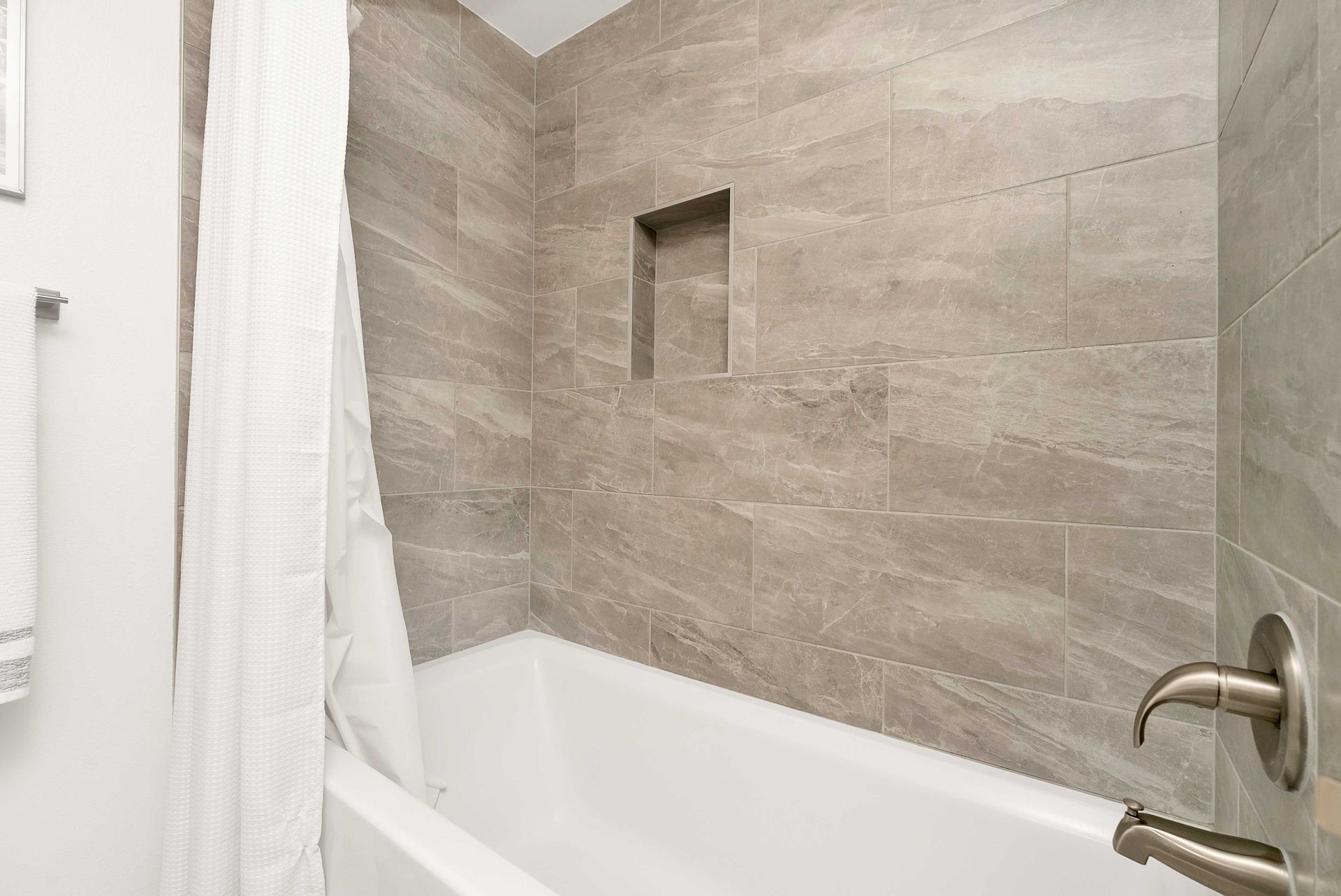 There is a bathtub in the bathroom with a shower curtain.