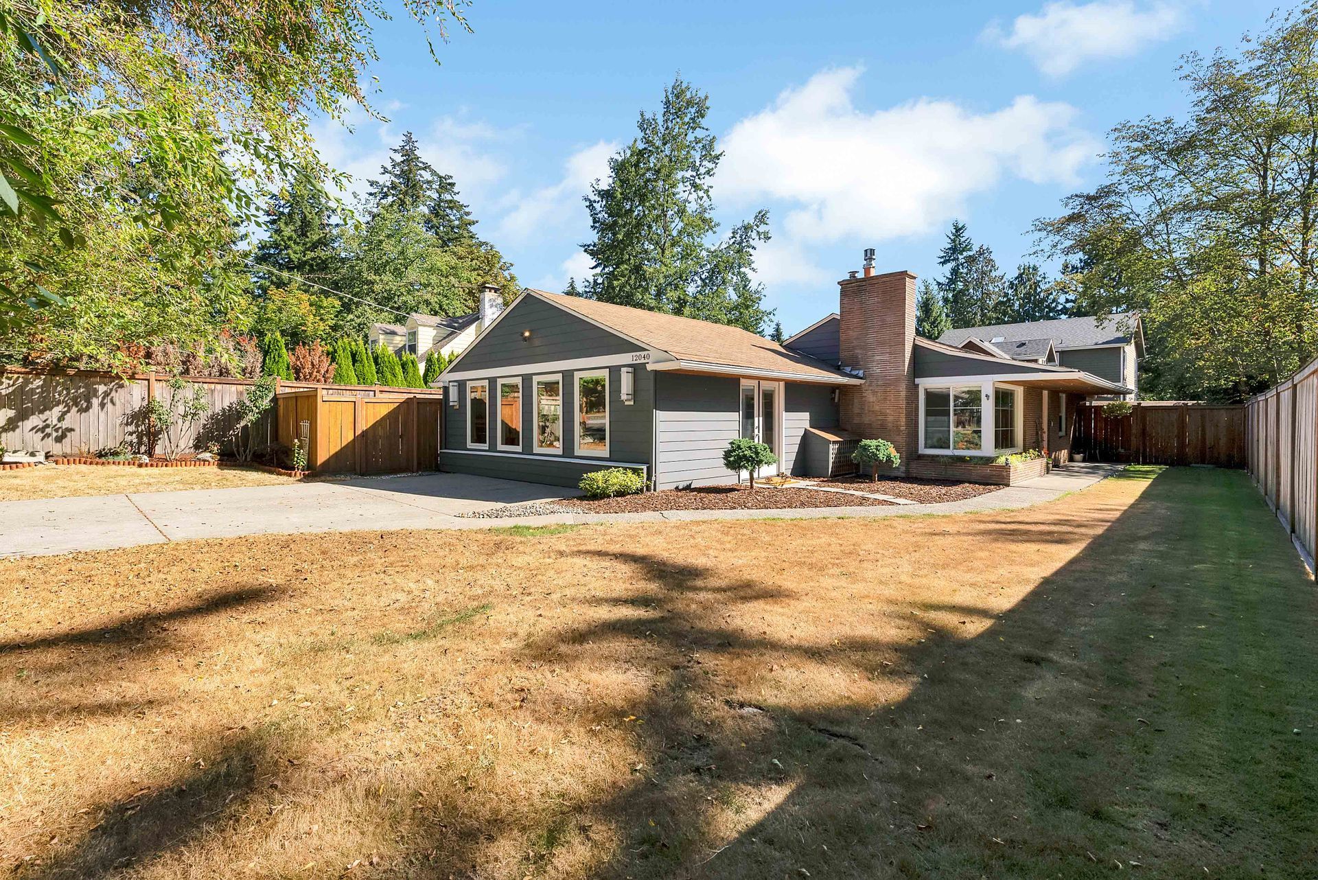 A house with a fence and a lot of grass in front of it