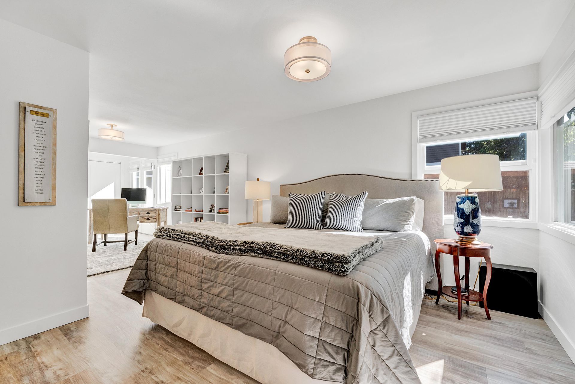 A bedroom with a large bed , lamps , and a window.
