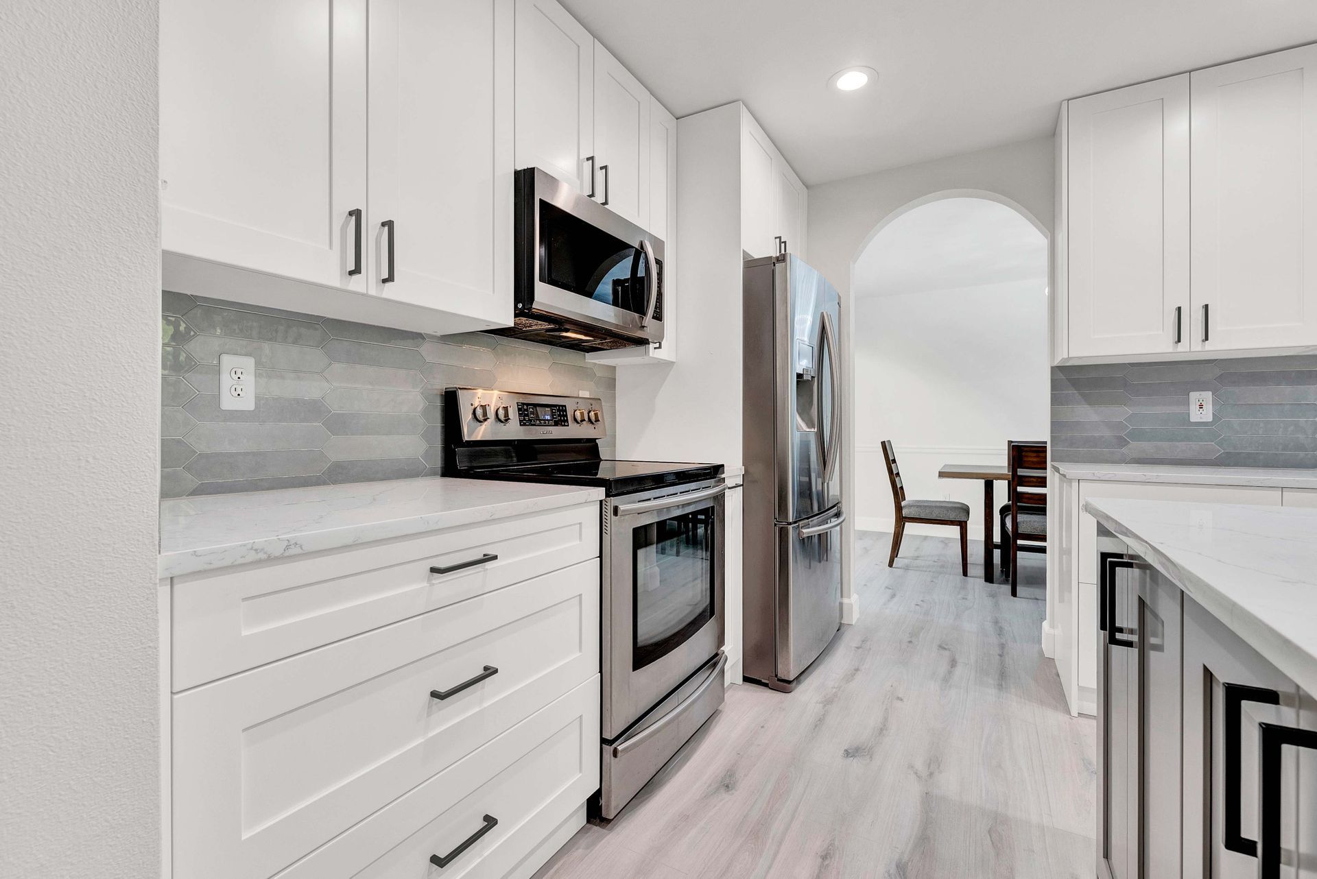 A kitchen with white cabinets and stainless steel appliances.