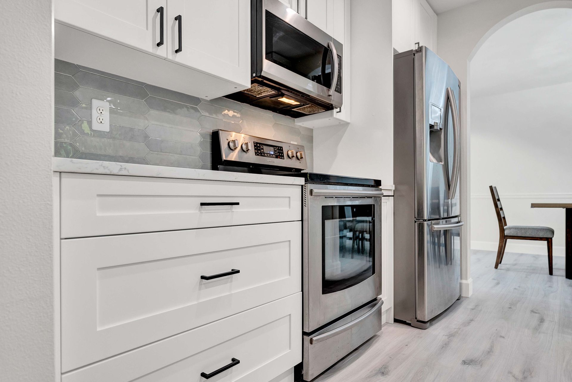 A kitchen with stainless steel appliances and white cabinets