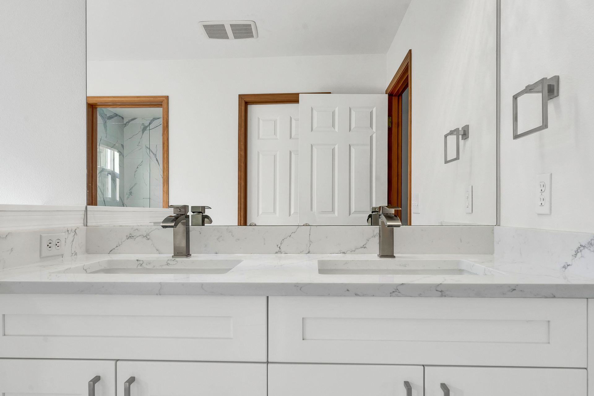 A bathroom with two sinks and two mirrors.